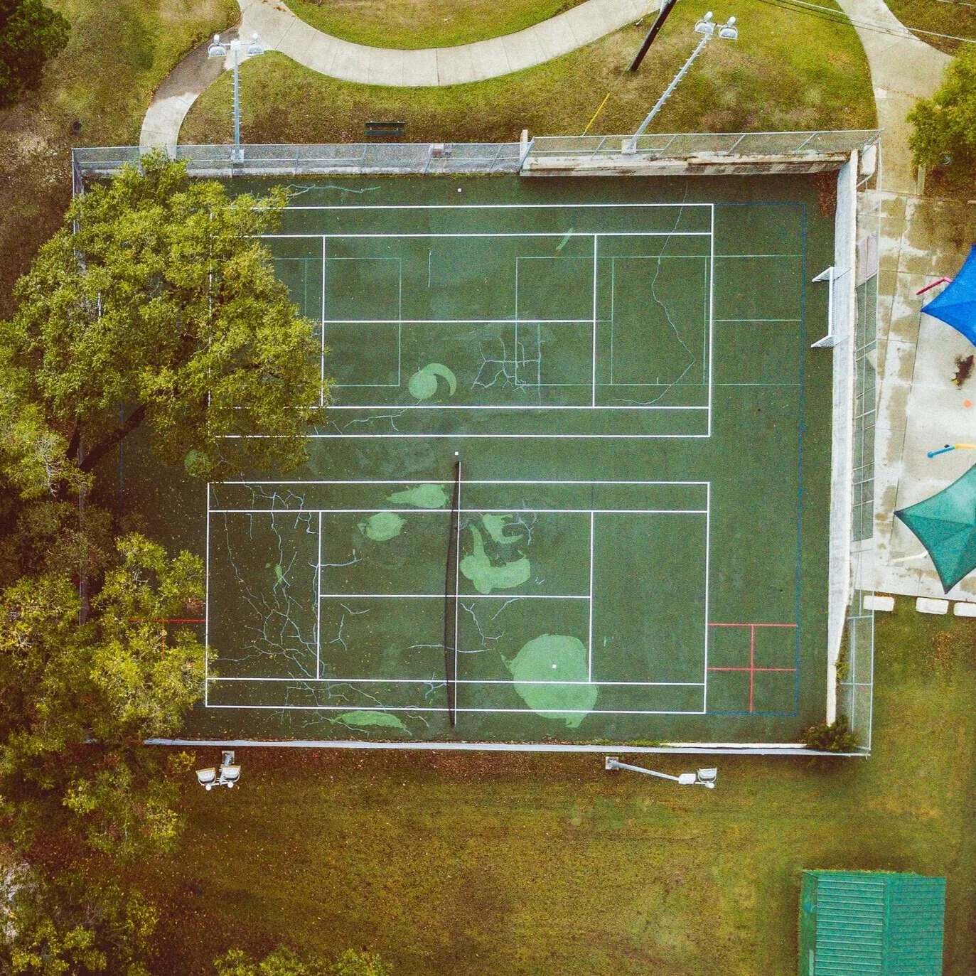 Stains, cracks that are exacerbated by weeds, and water damage can mean it’s time to call in a pro and have an assessment done of your court for the coming season.