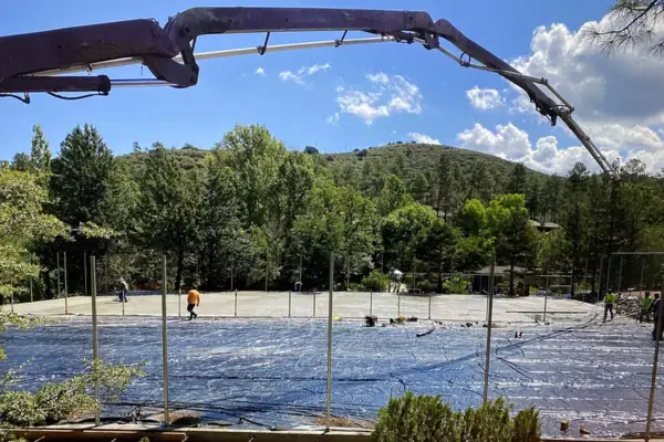 Concrete pump boom over a fresh court slab pour