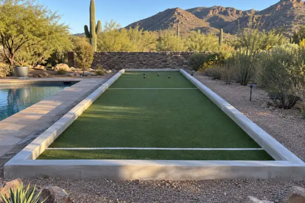 Rendering of a finished bocce court with a synthetic turf surface, white striping and concrete curbs beside a pool in the Tucson foothills