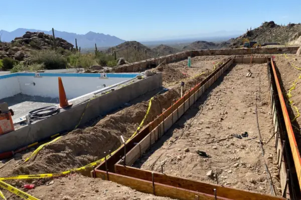 Wooden forms and rebar set for the curbs of a bocce court beside a pool build in the Tucson foothills